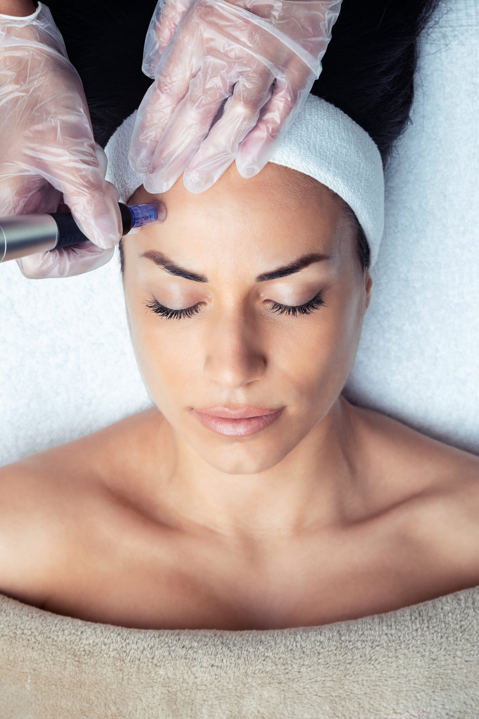cosmetologist making mesotherapy injection with dermapen on face